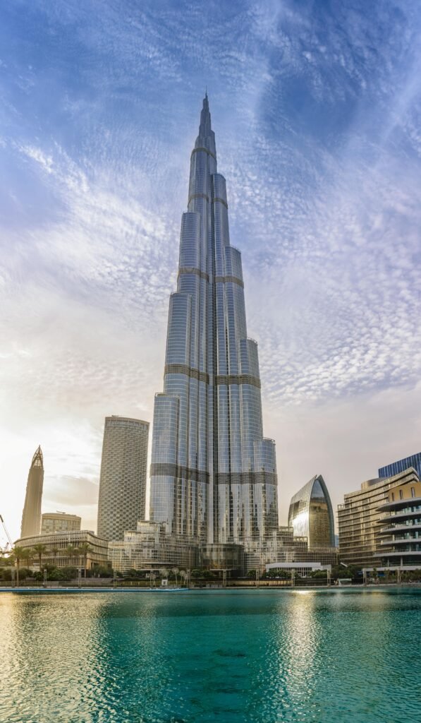 Majestic Burj Khalifa against a bright blue sky reflecting in water, Dubai.